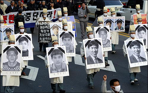 6일 오후 대학로에서 집회를 마친 노동자들이 최근 스스로 목숨을 끊은 노동자들의 영정사진을 들고 거리행진을 벌이고 있다. 